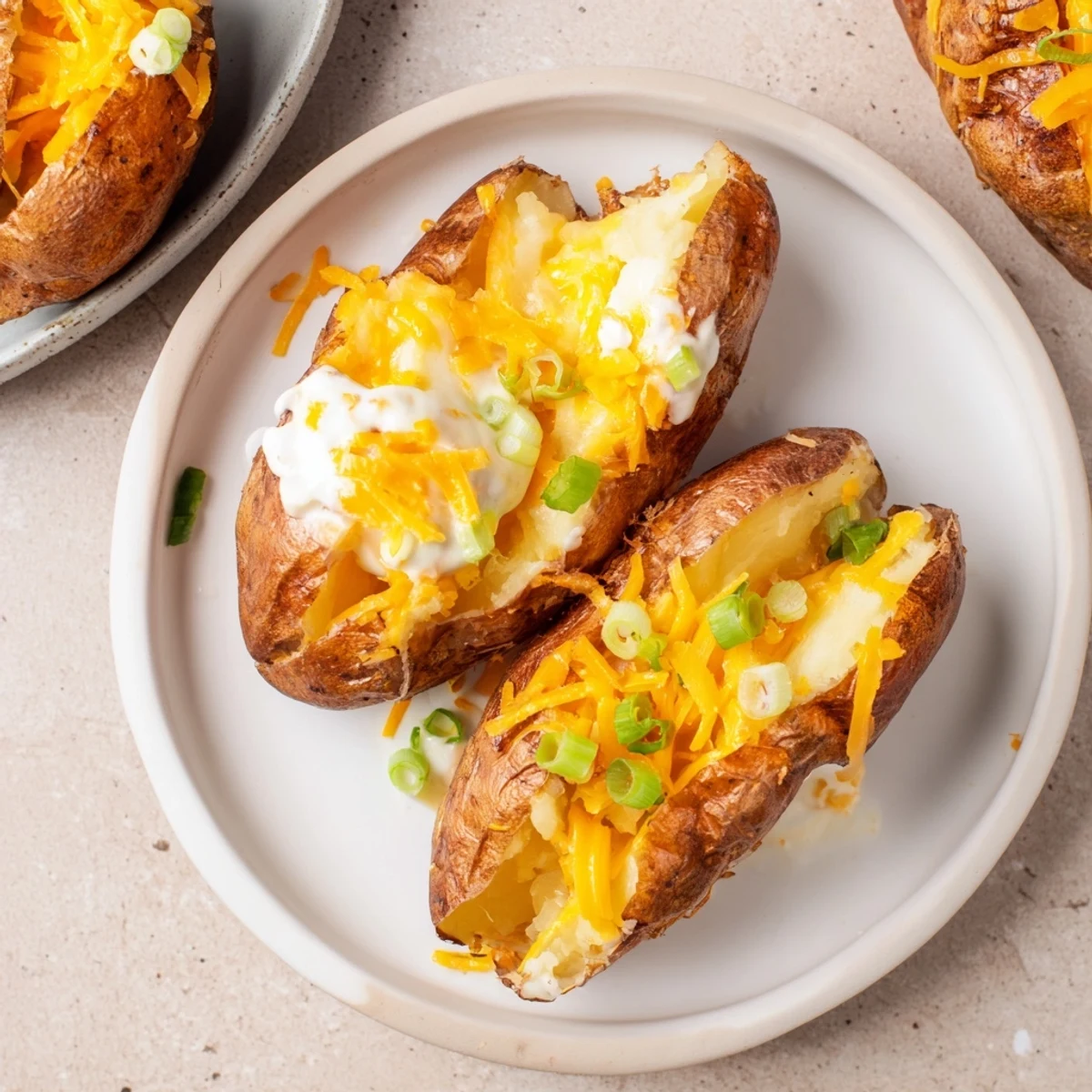 Golden-brown The Ultimate Baked Potato, steaming and fluffy, ready for butter, cheese, and chives.
