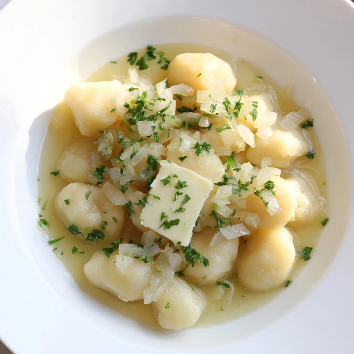 Warm Kartoffelklöße with a creamy sauce and garden vegetables, a hearty German meal.