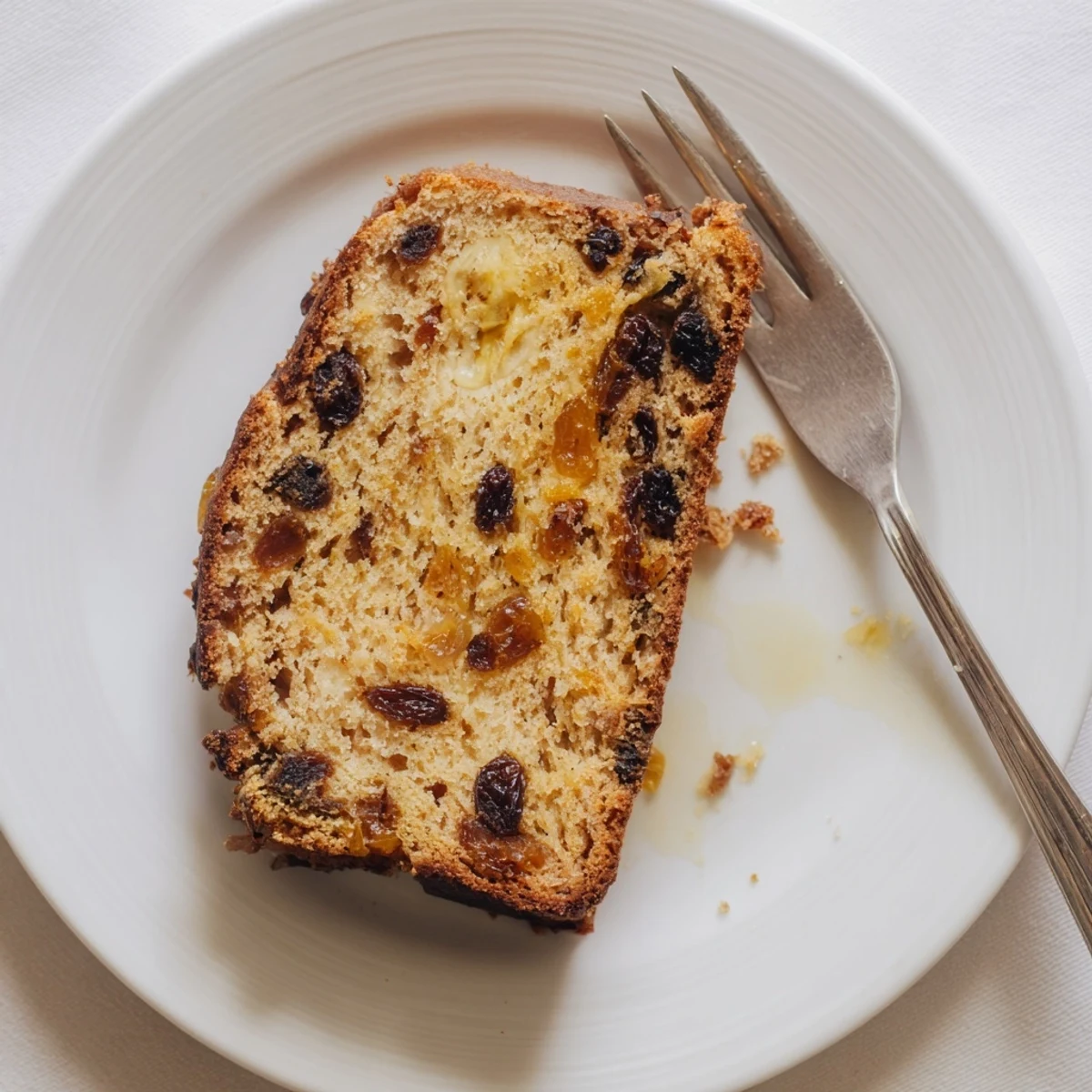 A close-up of warm, spiced Old-Fashioned German Raisin Bread, showing plump raisins perfectly baked.