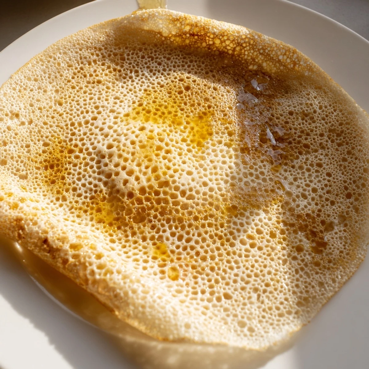 Deliciously porous Moroccan Baghrir pancakes steaming, perfect for a cozy weekend breakfast treat.