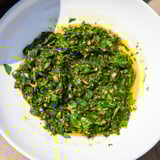 A close-up of vibrant Moroccan Chermoula Marinade, showcasing fresh cilantro and lemon zest before marinating.