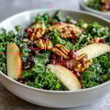 Healthy Kale and Pomegranate Bowl with crunchy walnuts, sweet apple slices, and bright pomegranate seeds.  