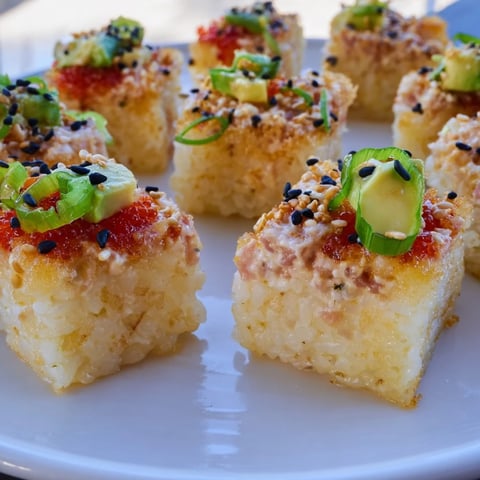 Golden, crispy spicy tuna crispy rice squares topped with creamy tuna and avocado, ready to eat.