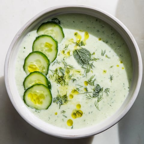 Creeamy Chilled Cucumber Garlic Soup, garnished with fresh dill and extra cucumber slices, is ready to serve.