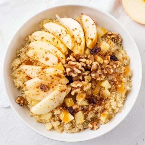 Warm and inviting apple cinnamon quinoa bowl, perfect for a cozy, healthy breakfast, topped with nuts.