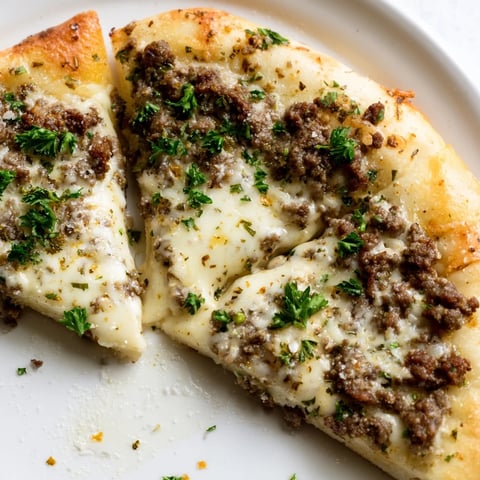 Hot Ground Beef Alfredo Pizza, bubbly mozzarella cheese melting over a savory beef base, ready to eat.