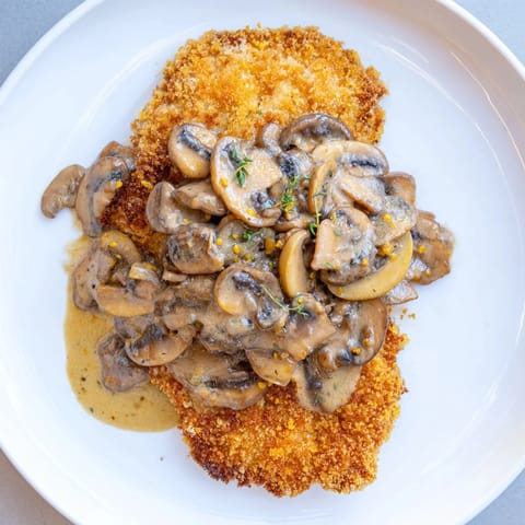 Golden-brown Jaeger Schnitzel with creamy mushroom gravy, perfect for a hearty dinner.