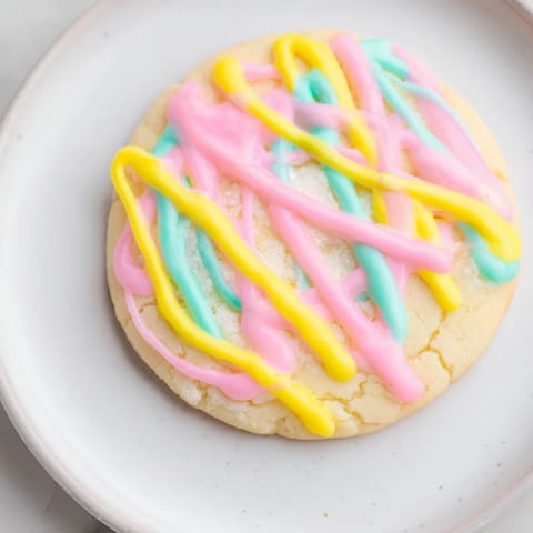 Freshly baked sugar cookies, beautifully drizzled with vanilla icing, ready to eat.