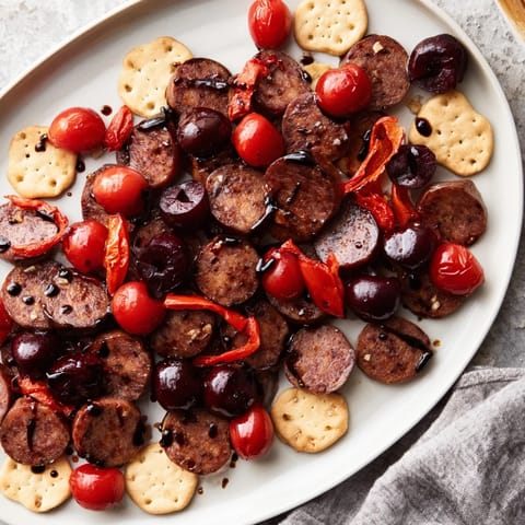 Spicy chorizo, cherry and pepper arrangement on crackers in the vibrant "Crimson Tide" appetizer recipe.