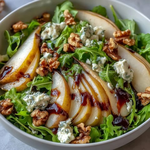 Ein leuchtend grüner Salat mit süßen Birnen und würziger Vinaigrette für gesunde Mahlzeiten.