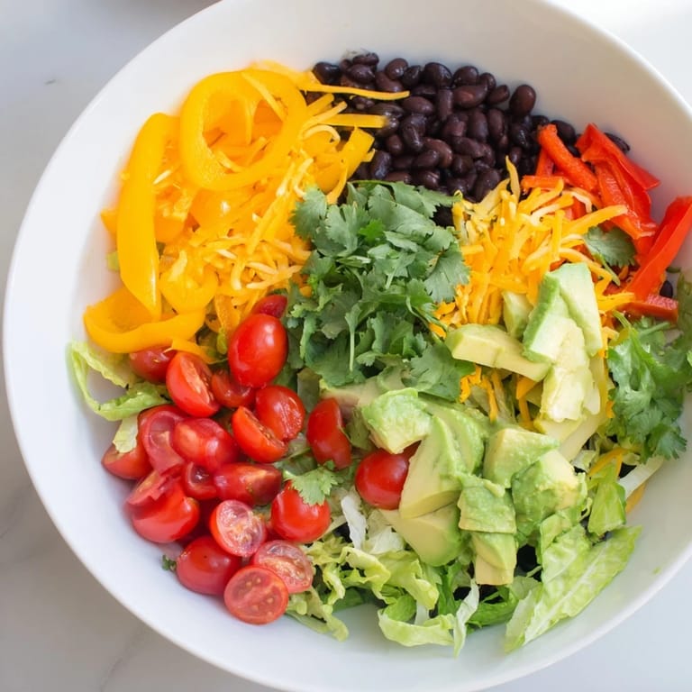 Vibrant Southwest Sunset Palette salad layers with colorful peppers, cheese, and black beans, perfect flavors.