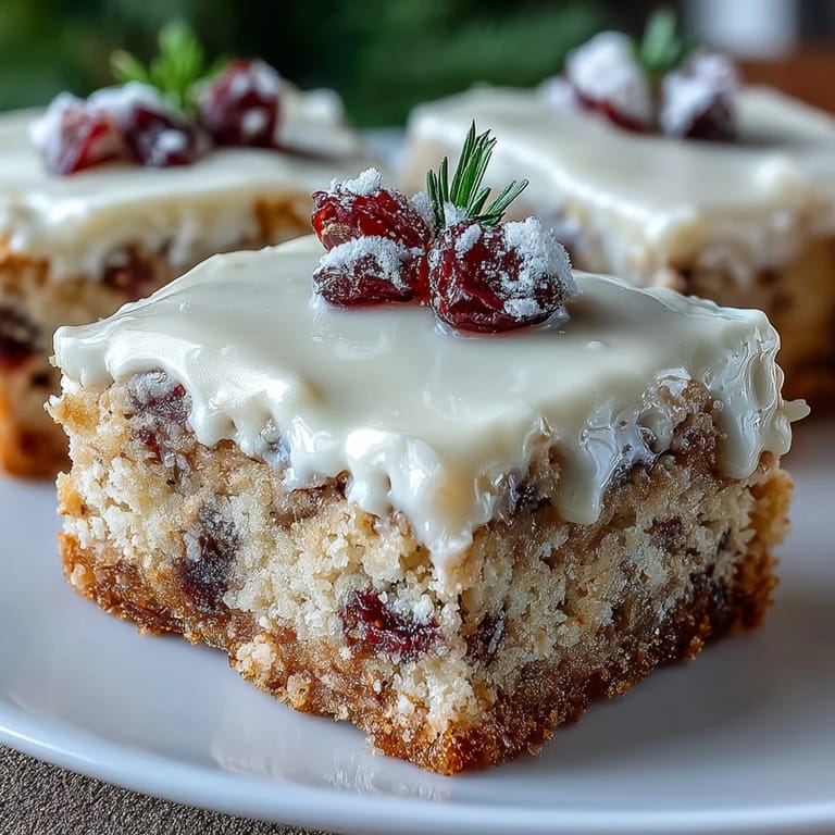 Freshly frosted Cranberry Bliss Bars garnished with dried cranberries, ideal for holiday dessert tables.