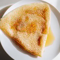 Golden, spongy Moroccan Baghrir crepes served warm with drizzled honey and melted butter.