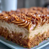 Goldener Decadent Baked Biscoff Cake mit cremiger Lotus-Frostung und zerkrümelten Biscoff-Keksen.